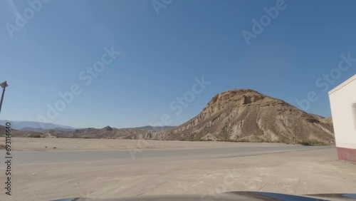 First person view, FPV, from dashcam of car driving on highway in Tabernas desert, Almeria, Andalusia, Spain, Europe. Road trip video in POV in arid, dry climate photo