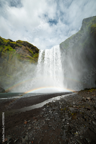 Long exposure view of famous Skogafoss waterfall with colourful sky and double rainbow. Magnificent Iceland in august. Fimmv  r  uh  ls Hiking Trail. Popular Travel destinations