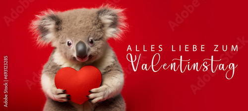 Alles Liebe zum Valentinstag, Grußkarte mit deutschem Text - Niedliche stehender Koalabär Koala hält rotes Herz , isoliert auf rotem Hintergrund © Corri Seizinger