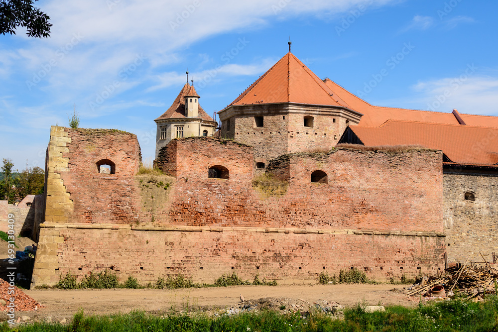 Renovated old historical buildings  of Fagaras Fortress (Cetatea Fagaras) during renovation works in a sunny summer day, in Transylvania (Transilvania) region, Romania  .