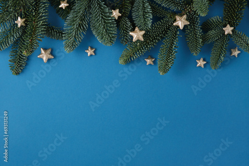 Christmas blue background with fir tree and stars. Top view with copy space for your text photo