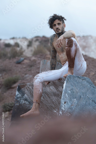 tattooed man with piercings shirtless posing