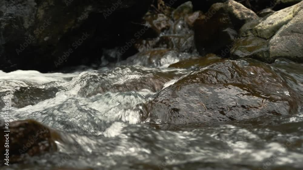 Wild mountain river. close-up. fast small mountain river with crystal clear water. Rapid water flow running through stone rapids and over the stones in wilderness area, in the forest. river rocks Wild mountain river. close-up. fast small mountain river with crystal clear water. Rapid water flow running through stone rapids and over the stones in wilderness area, in the forest. river rocks
