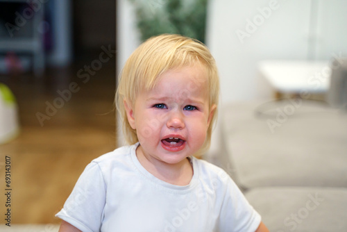 A crying child at home, face red and in tears