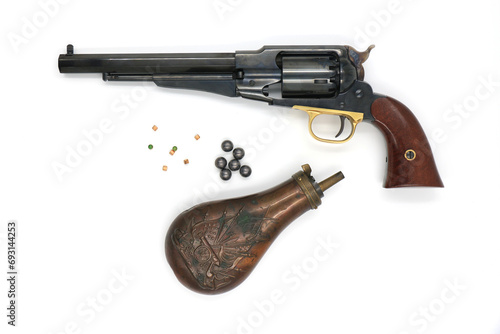 Black powder percussion revolver Remington 1858 New Army and the equipment such as a gunpowder flask, lead balls and percussion caps on a white background. Left side.