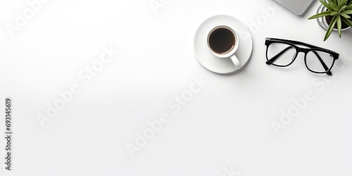 Mock up of a white office desk with computer, pen, eyeglass, notebook, and cup of coffee, seen from the top view, with copy space. photo