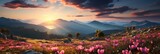A vibrant field of pink flowers swaying gently in the breeze, with majestic mountains towering in the background