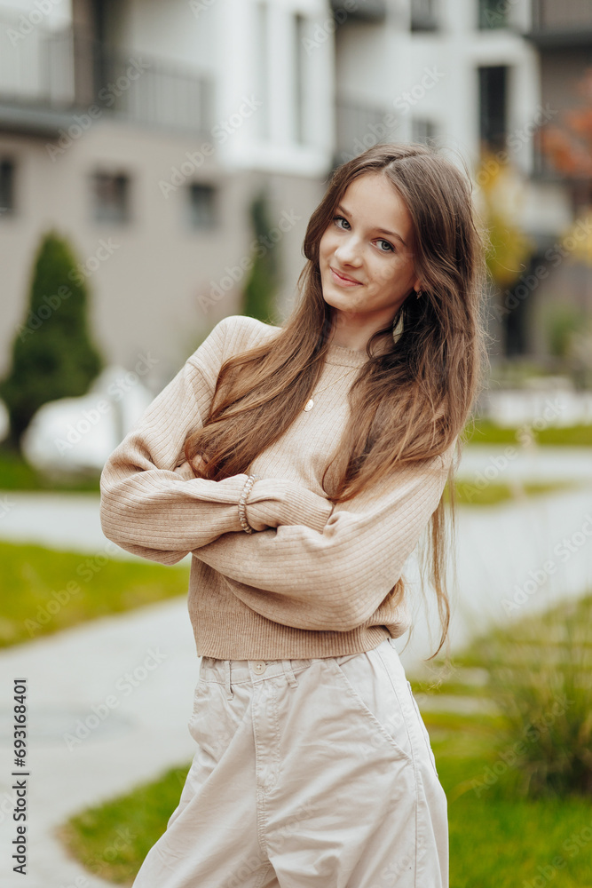 Vertical photo. Beautiful carefree young teenage girl in casual clothes. Portrait of a beautiful girl against the background of nature with a blurred background. Vertical photo. Beautiful carefree young teenage girl in casual clothes. Portrait of a beautiful girl against the background of nature with a blurred background.