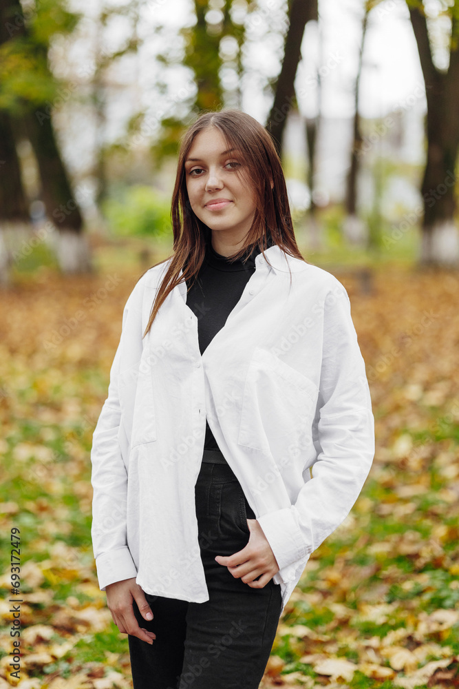 Vertical photo. Beautiful carefree young teenage girl in casual clothes. Portrait of a beautiful girl against the background of nature with a blurred background. Vertical photo. Beautiful carefree young teenage girl in casual clothes. Portrait of a beautiful girl against the background of nature with a blurred background.