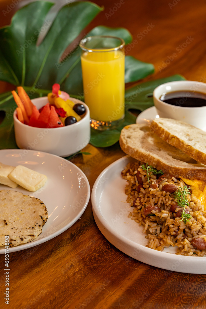 Colombian breakfast with arepas, coffee, bread, eggs, warmed rice and fruit