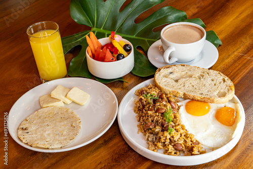 Colombian breakfast with arepas, coffee, bread, eggs, warmed rice and fruit
