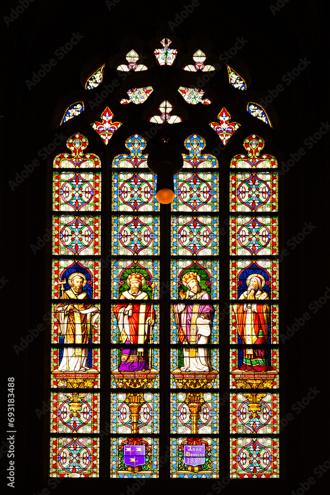 Stained glass window depicting a saint performing the sacrament of Holy Communion in St. John's Cathedral, in den Bosch, Netherlands.