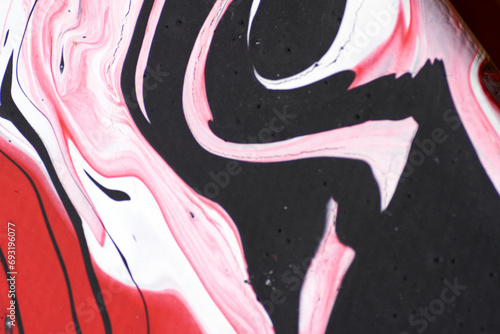 Marbled acrylic colored pattern in the colors red, black, white and pink.