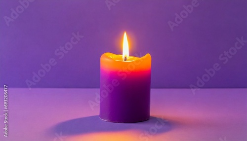 purple candle on a purple background a bright orange light