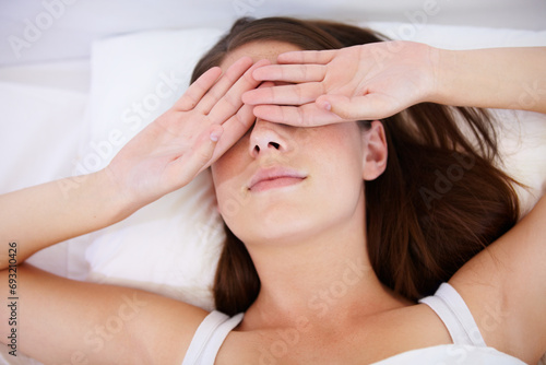 Fatigue, wake up or tired woman in bed with hands on eyes frustrated with insomnia, crisis or disaster. Bedroom, burnout or lady person in house with sleeping issue, struggle or low energy from above photo
