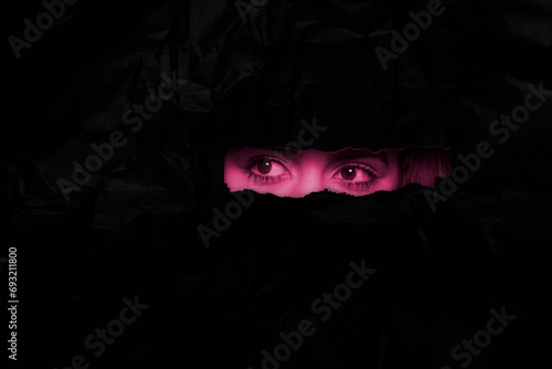 Canvas Print Eyes of a woman peeping through a hole, curious eyes spying