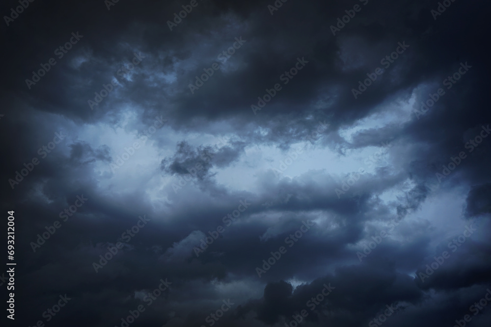 Black dark blue gray sky with heavy clouds. Dramatic background. Storm hurricane wind rain cloudy. Ominous scary creepy. Gloomy atmosphere. Black dark blue gray sky with heavy clouds. Dramatic background. Storm hurricane wind rain cloudy. Ominous scary creepy. Gloomy atmosphere.