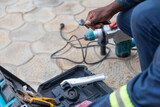 Close-up of an open electrician's toolbox resting on the cobblestones