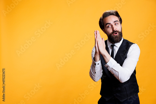 Young adult butler applauding on camera, doing standing ovation gesture and congratulating person on achievement. Male experienced waiter clapping hands and cheering for someone. photo