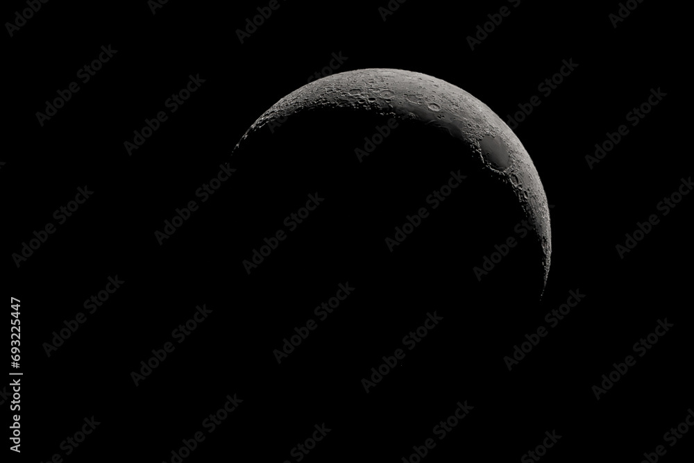 Crescent moon photographed with a telescope, where you can see the craters and the lunar surface, it will soon be a moon landing site