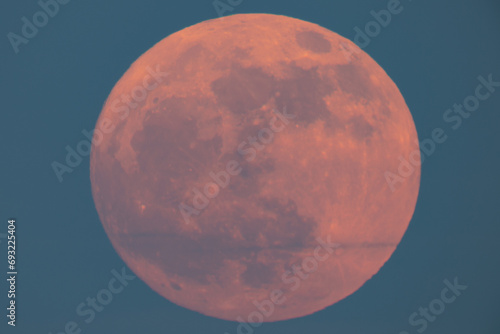 Super strawberry moon rising over the sea, a reddish full moon rising over the sea on a summer night. full moon