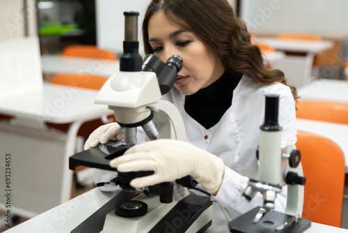 female doctor looking through the microscope  examine patient s analysis