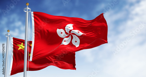 Flags of Hong Kong and China waving in the wind on a clear day photo