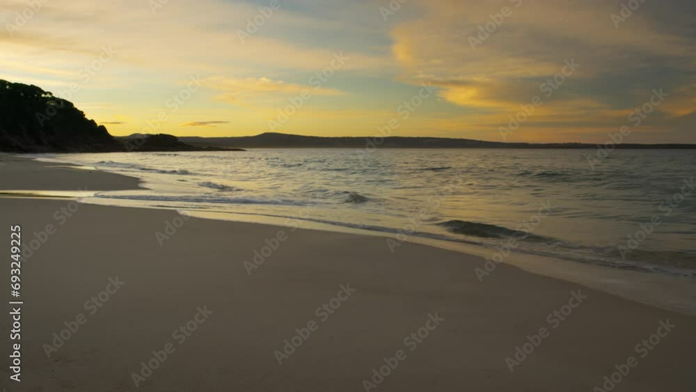 Waves breaking on a rocky beach at sunset with a beautiful orange sunset sky above, on the coast of Australia. Waves breaking on a rocky beach at sunset with a beautiful orange sunset sky above, on the coast of Australia.