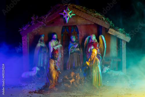 Christmas decorative creche with Holy family. Christmas scene birth of Jesus. Christmas manger scene with figurines including Jesus, Mary, Joseph, lamb. Biblical Mary holding Jesus. Christmas theme. photo