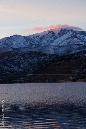 pink clouds over utah mountain by lake in winter at sunset