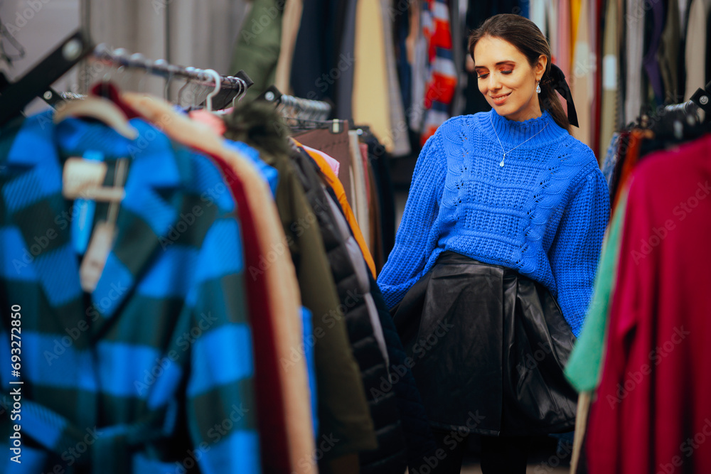 Trendy Woman Wearing a Blue Sweater Buying Warm Clothes. Elegant chic fashionista looking for new clothes in a store
