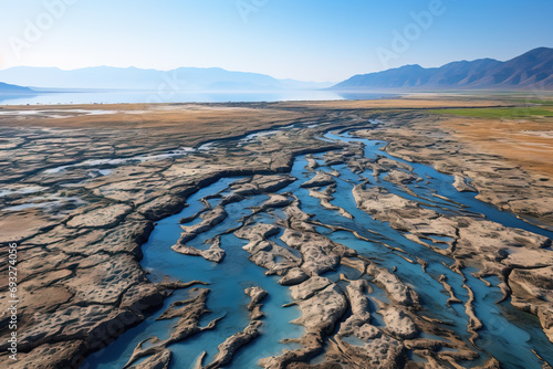 Aerial view of meandering water channels cutting through a dry, textured landscape. photo