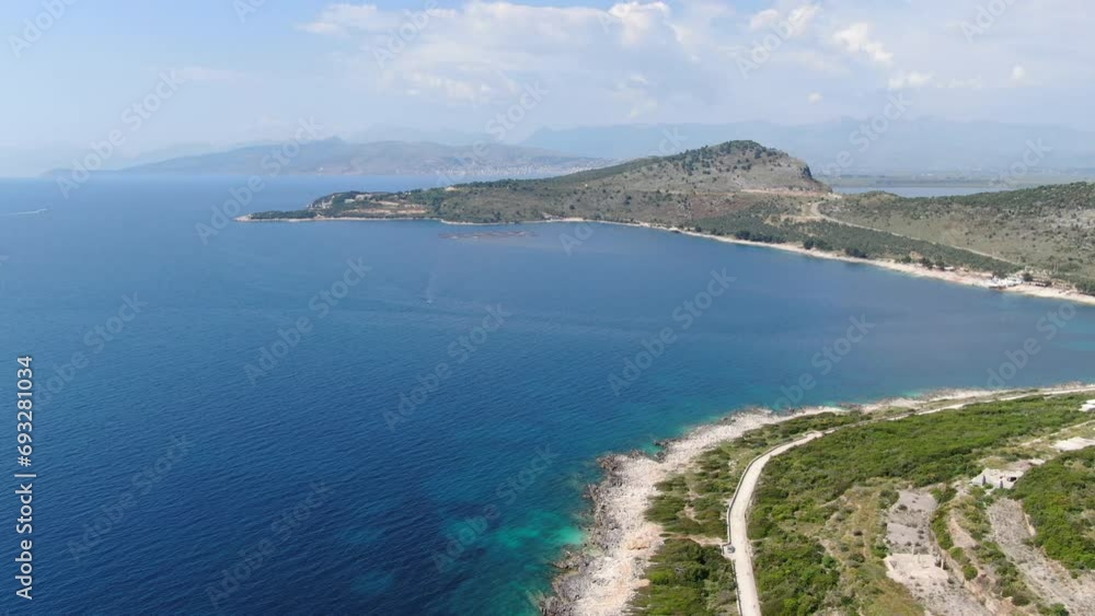 Drone view in Albania flying over blue water sea next to green mountains landscape, sunny day in Ksamil Drone view in Albania flying over blue water sea next to green mountains landscape, sunny day in Ksamil