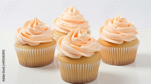 Pastel peach colored icing on cupcakes