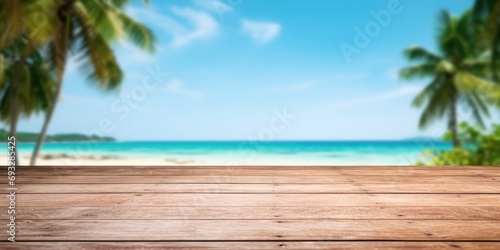 Montage of a tranquil tropical beach with a wooden table and space for product ad against a blurry sky and sea background.