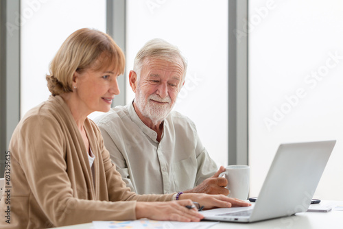 Senior couple checking their bills, retired elderly family reading documents