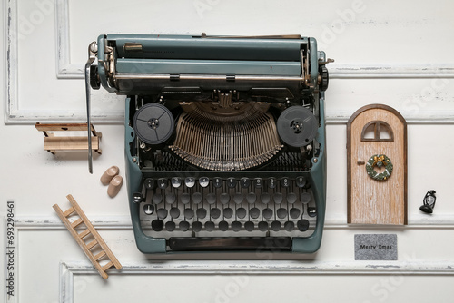 Vintage typewriter with Christmas decor on white wooden background