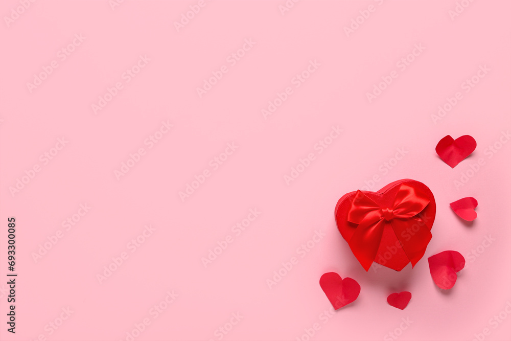 Gift box and paper hearts on pink background. Valentine's Day celebration