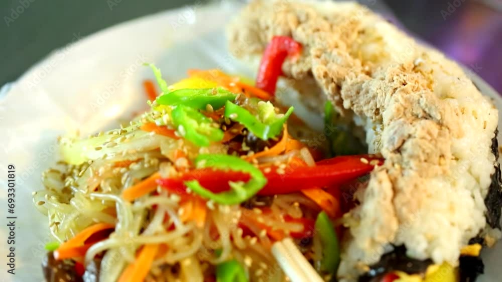 한국 음식 잡채와 하얀색 쌀 밥위에 올려진 다진 참치를 올린 누드 김밥이 먹음직스러운 한국 음식 잡채와 하얀색 쌀 밥위에 올려진 다진 참치를 올린 누드 김밥이 먹음직스러운