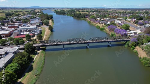 Kempsey Bridge Across Macleay River With View Of Jacaranda Trees And Shopping Mall In NSW, Australia. aerial pullback photo