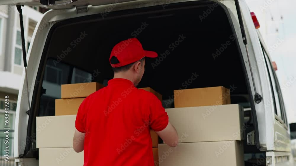 Delivery man, driver in red orange uniform is calling to customer for sending parcel box package in the cargo truck at home Delivery man, driver in red orange uniform is calling to customer for sending parcel box package in the cargo truck at home