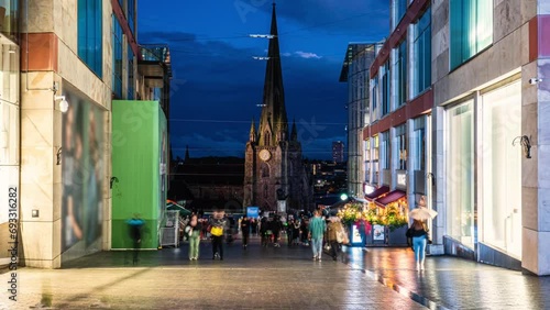 Time lapse of Birmingham St Martin church and Bull Ring Shopping Centre with crowd people and tourist walking in the city of Birmingham at night, West Midlands, England photo