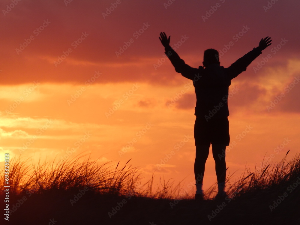 Silhouette eines glücklichen Jungen beim Sonnenuntergang
