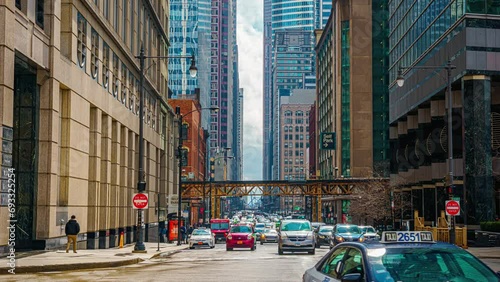 Time lapse of Crowd pedestrian and tourist walking and crossing intersection at Railroad bridge with traffic among modern buildings of Downtown Chicago, Illinois, United States photo