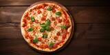 Top-down view of Margherita pizza on wooden background, with space for text.