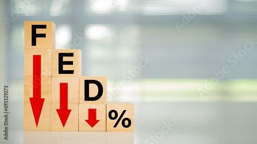 Federal Reserve bank interest rate reduction concept. Wooden blocks with fed and arrow go down. photo
