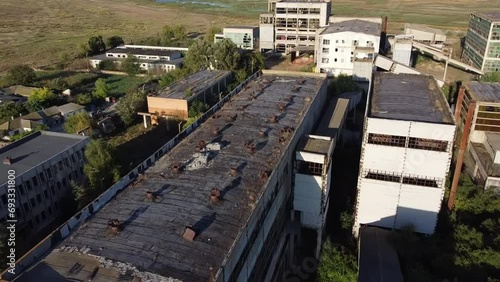 Approaching drone shot of run-down buildings of a rare metals enterprise that used to produced materials for nuclear energy, located in Vadu, Romania. photo