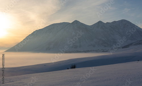 A snowy and foggy landscape, with Mount Kirkor and a village on its foothills in the background, Tatvan, Bitlis