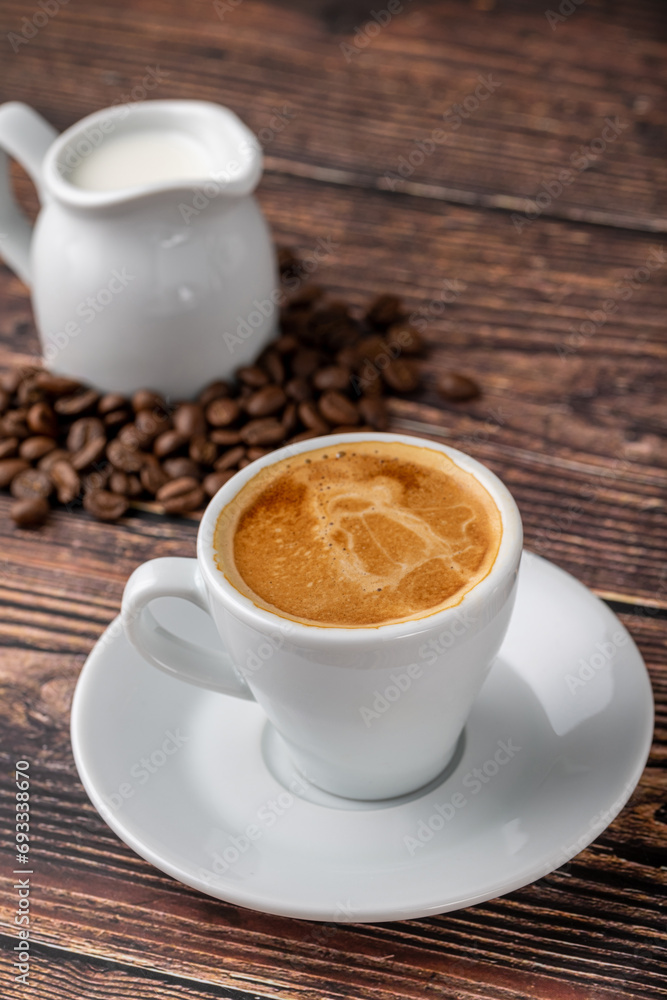 Fresh espresso coffee together decorated with coffee beans on wooden table Fresh espresso coffee together decorated with coffee beans on wooden table