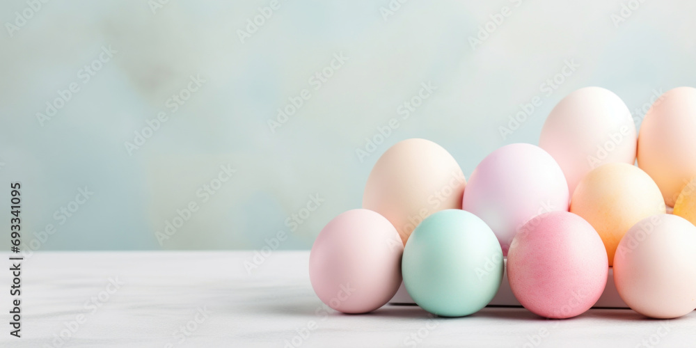 Easter background with pastel colored eggs on a white wooden table
